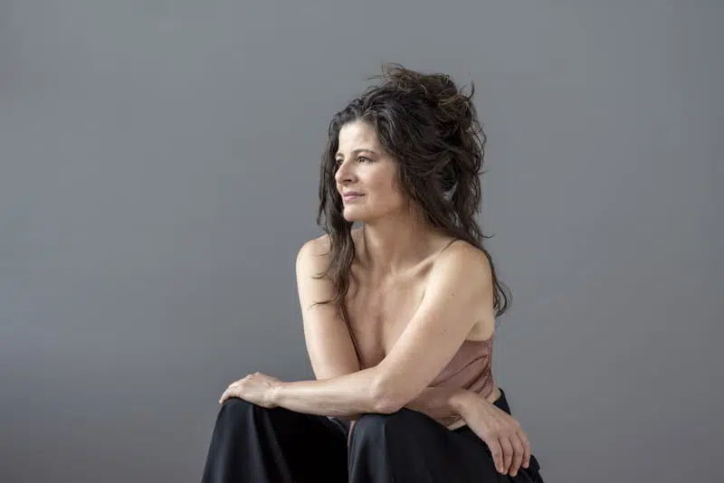ElenaMessyHairDream Elena Ciampa side view, sitting with arms crossed on legs